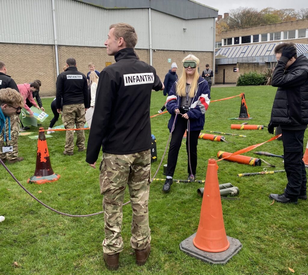 Blindfolded students taking part in an obstacle course to test communication and team work skills