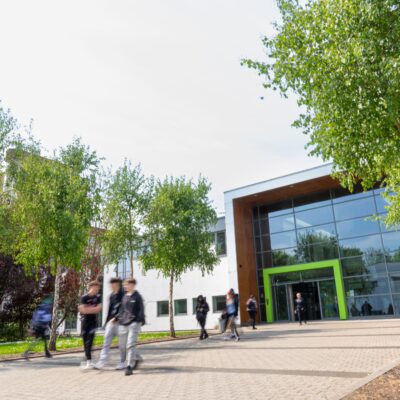 The front of the college building on Infirmary Road with students walking into the building